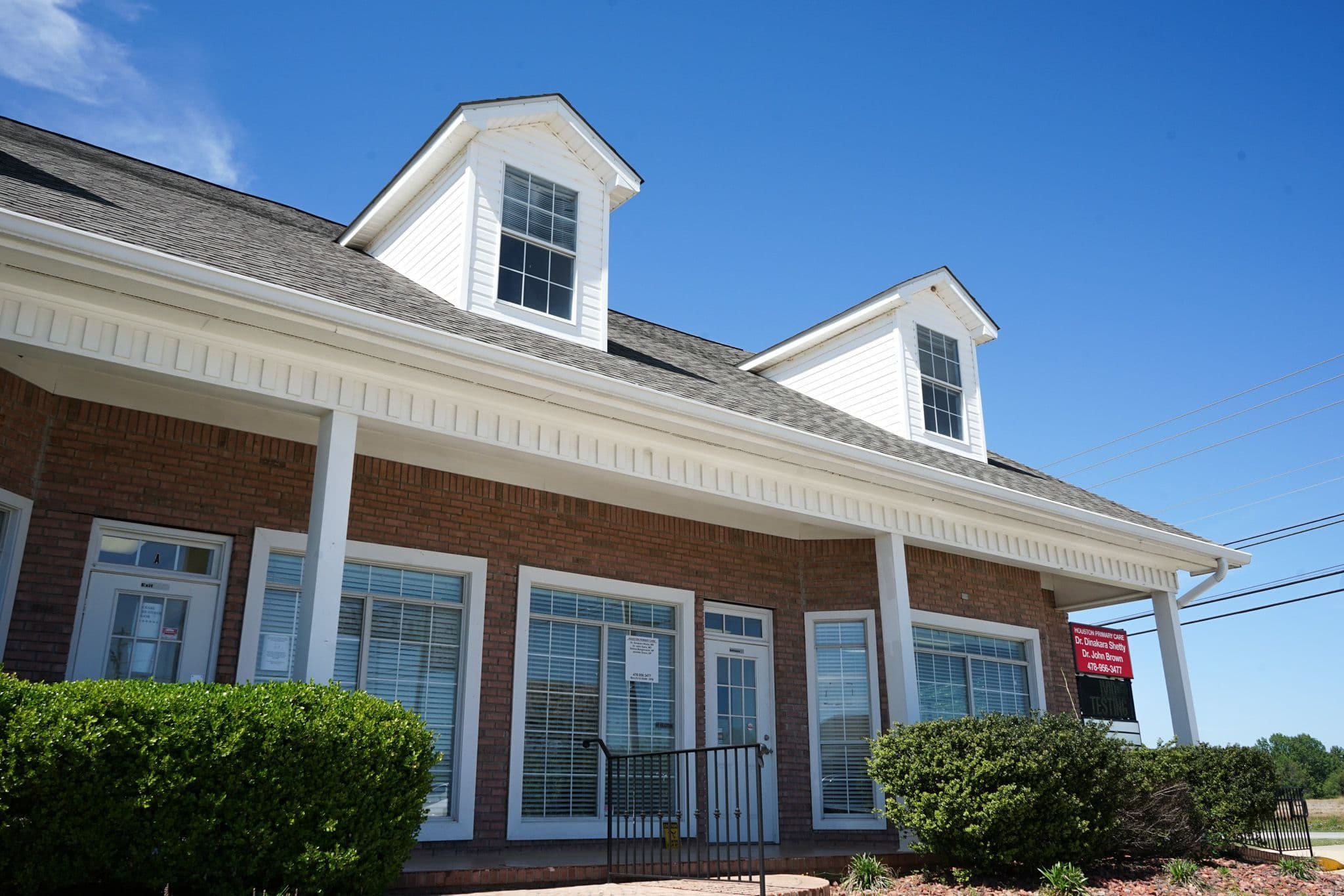 a large brick building with a white roof and a lot of windows .