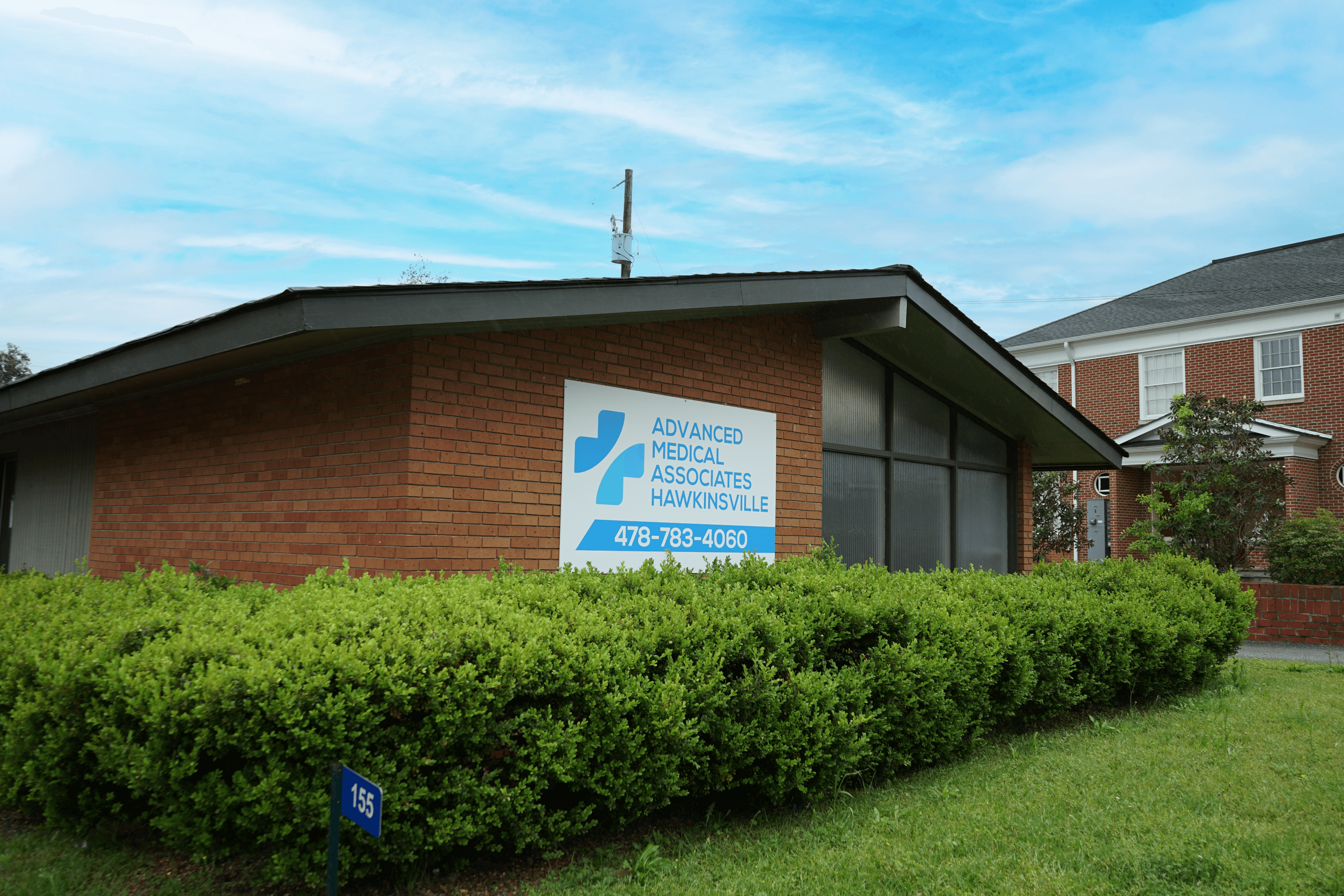 a brick building with a sign that says advanced medical associates hawkinsville